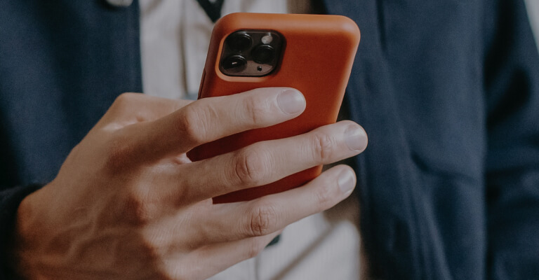 A man in a suit is holding a cell phone.